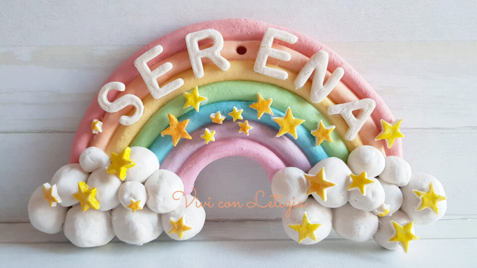 arcobaleno di pasta con stelline, nuvole in basso a destra e sinistra, nome Serena in alto